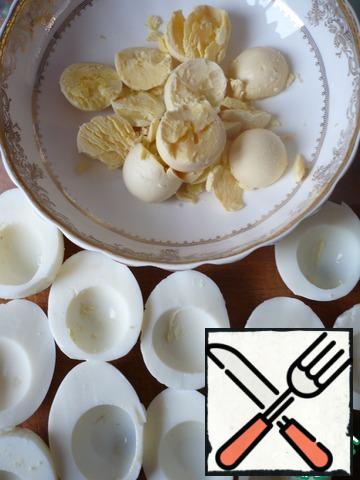 Boil the eggs and peel. Then carefully cut in half, divide into whites and yolks.