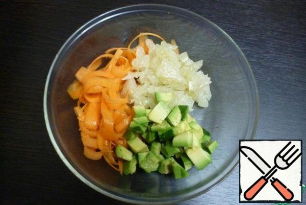 Parse the pomelo into slices and remove the white film. Divide into pieces. Collect the juice. Peel and slice the avocado and pour the juice over the pomelo so that it doesn't darken.
Combine the carrots, pomelo and avocado pieces in a bowl.