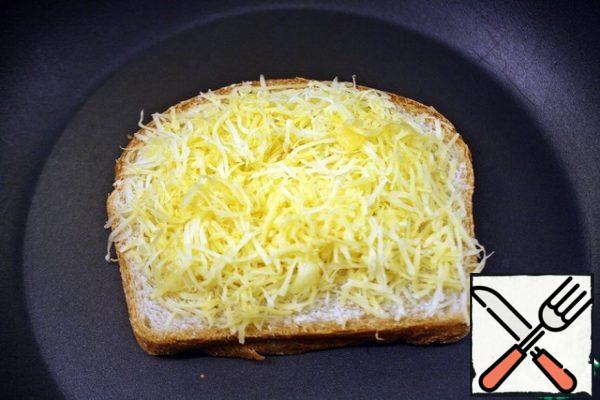 On the fire, slightly below medium, heat a frying pan, put a slice of bread with butter down, spread the cheese mixture on top, cover with bread butter up, lightly press down with a spatula and close the lid, fry for a couple of minutes until golden brown.
