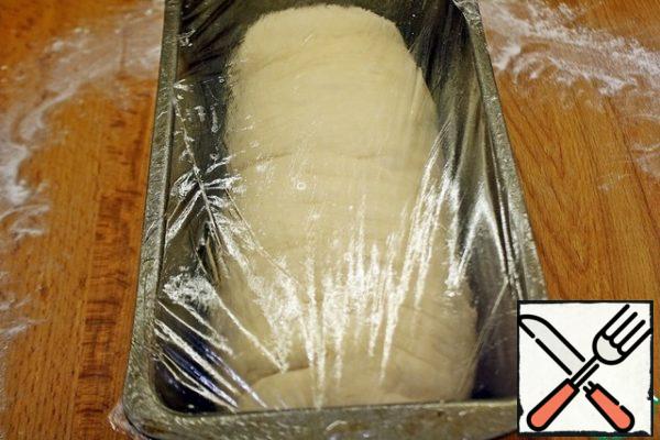 Then put in a greased form seam down. Be sure to correct the dough, the dough should lie flat, evenly - this will depend on the shape of the bread. Take the plastic wrap, lubricate with oil and cover the dough with the oil side down. Leave in a warm place for 1-1. 5 hours.