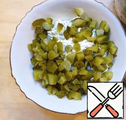 Cut the gherkins and mix with the curd mass.