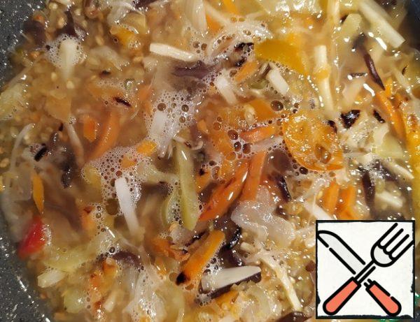 Then pour hot boiled water over everything. Cover the pan with a lid and simmer on low heat for about 15 minutes, until the liquid in the pan almost completely evaporates.