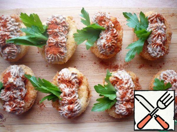 Garnish the stuffed eggs with sprigs of parsley and lightly sprinkle sweet paprika on top.