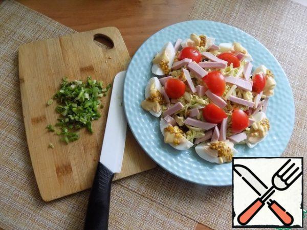 Now cover the salad with the second half of the smeared Peking cabbage. Again we spread tomatoes, sausage and whole olives. Finely chop the green onion, you can add some more greens: dill and parsley.

