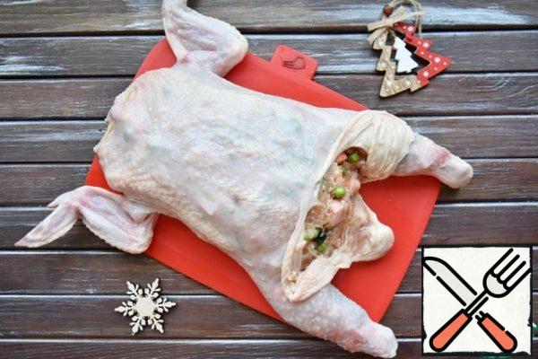 Spread out the skin of the bird and fill it with the prepared filling. It is not necessary to fill the shell tightly, it may burst when baking.
Fix all the places of breaks and holes with wooden toothpicks.
