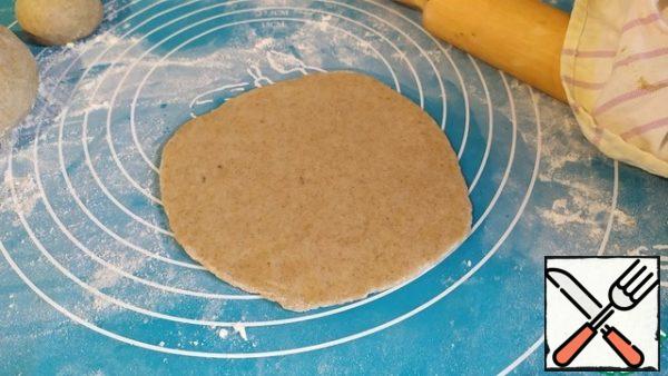 Take 1 bun and roll it into a flat cake. Grease the tortilla with vegetable oil. Fold in half.