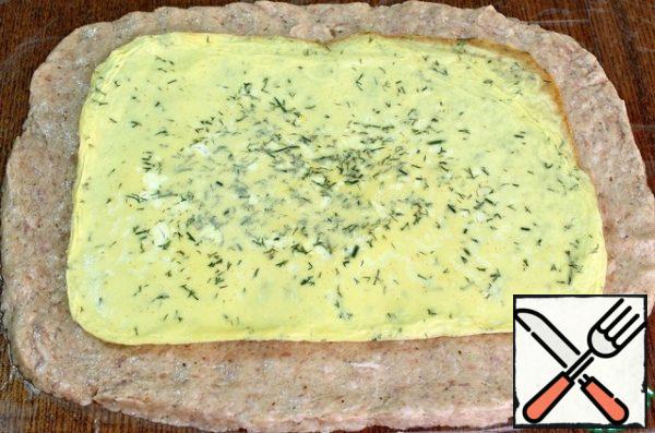 Sprinkle the table with water, cover with plastic wrap (or cellophane bag) and put the minced meat on it in an even layer in the form of a rectangle.
Put the omelet on minced meat (you can sprinkle with cheese) and roll it up with a roll using a film.
