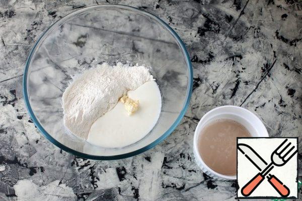 In a bowl, sift 100 g of flour, add salt, butter, kefir (warm) and yeast solution.
