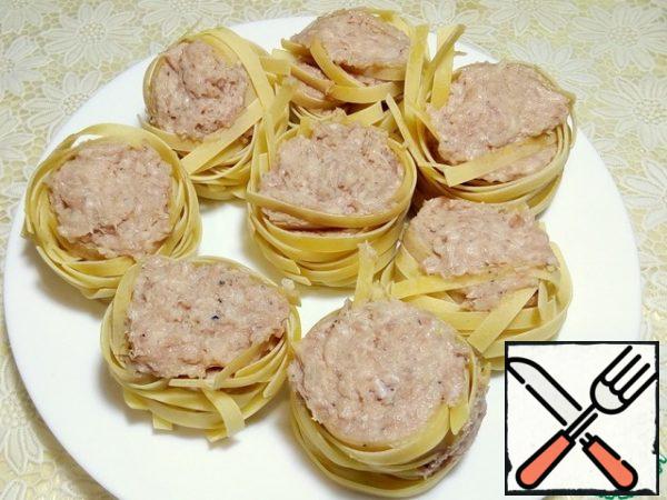 Stuff tightly with meat, raw pasta nests with a teaspoon.