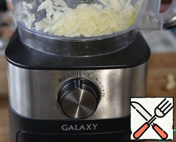 We start with the preparation of the filling. Onions are cleaned and crushed, I used a food processor shredder for this.