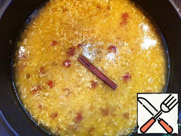 Pour the broth, orange juice, add a cinnamon stick.
My broth is homemade, salty. If you don't have salty broth, add salt.
Cover the pan with a lid, reduce the heat to low and leave the rice for 15-20 minutes. All liquid must be absorbed.
Important: do not stir the rice during cooking.