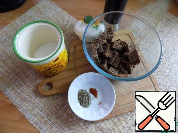 Cut four slices of Borodino bread. Cut them in half and cut them into long cubes with a width of half a piece. Put it in a bowl.
