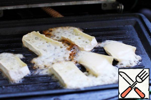 Fry the pieces of brie cheese on a dry grill.
