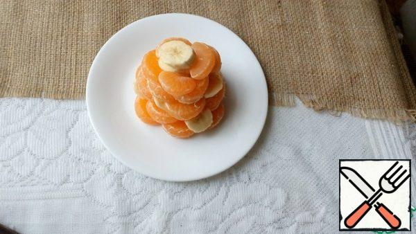 Peel the kiwi, cut into thin rings. We spread it on the pyramid, forming "twigs".