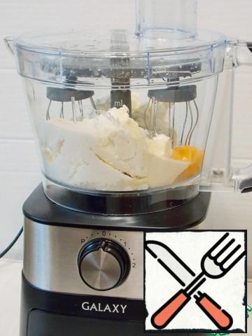 To make this casserole, I will use the  food processor. It is very convenient both in Assembly and in operation, with a large bowl. In the bowl of the combine, put the cottage cheese, cream cheese, sugar, semolina and break the egg. Install the beaters and close the lid until it clicks. Preheat the oven to 170 degrees.