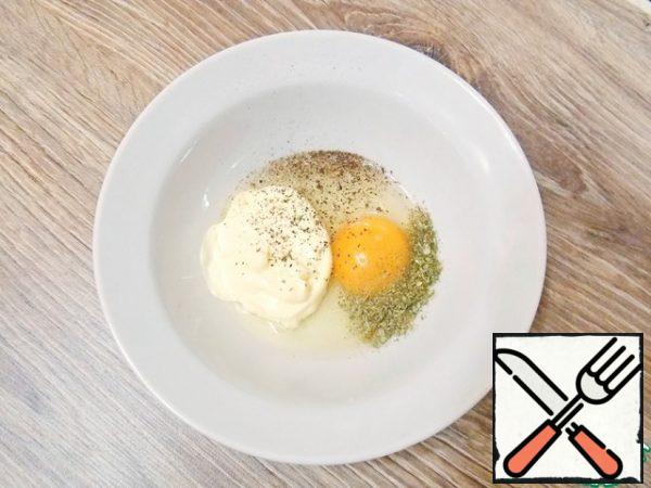 In a bowl, put mayonnaise, parsley, salt, break an egg, black pepper and mix.