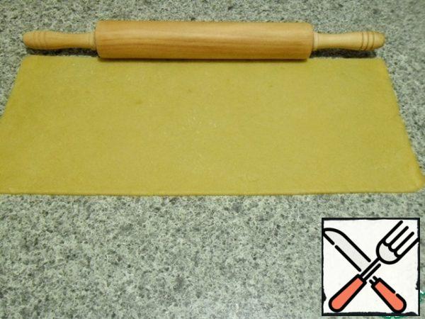 I specially made a photo with a rolling pin, so that it was clear how much the dough increased when rolling.
The thickness of the dough is 2-3 mm.
Rolled without podpira flour, the dough slid down the counter tops perfectly.
The dough is very tender, shortbread. It is better to roll in one direction, but not as on dumplings.