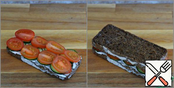 Put the tomato slices on the cucumber and cover the sandwich with a second slice of bread.
