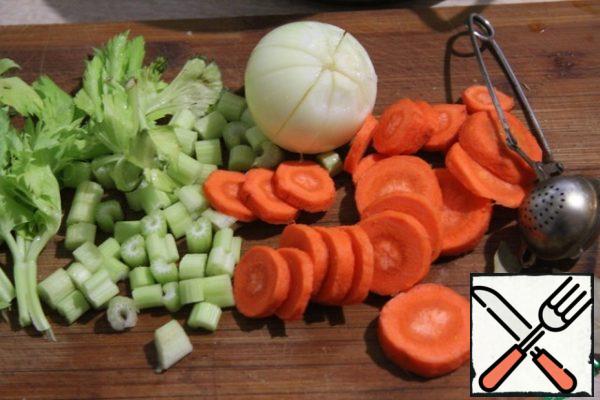 Cut the carrot into circles, leek or regular onion rings, and cut the celery stalks into small cubes.