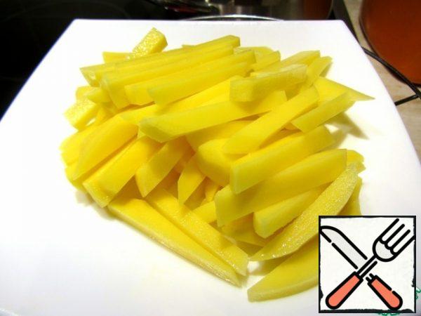 Pour the wine and water, stir the resulting sauce. Cut the potatoes into strips and place them in the pan.