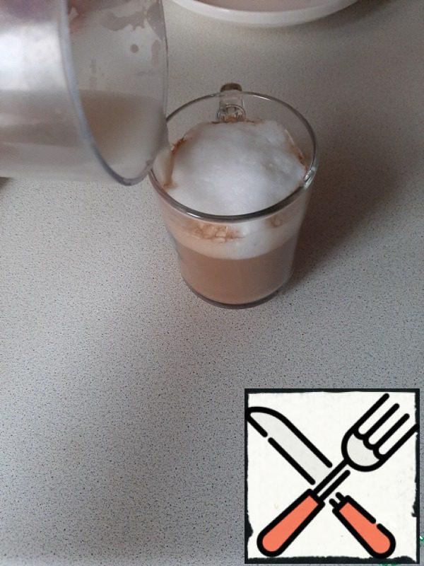 Spoon the foam from the milk into a Cup of coffee, and carefully pour the remaining milk in a thin stream along the edge of the Cup.