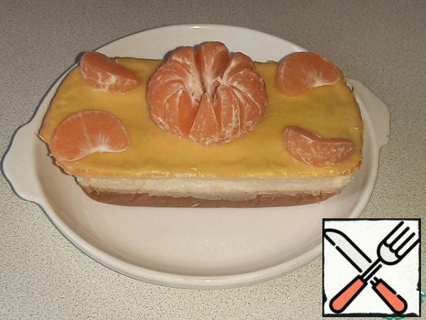 Remove the finished dessert from the mold along with the foil, remove the foil, put it on a plate and decorate the cake with tangerine slices.