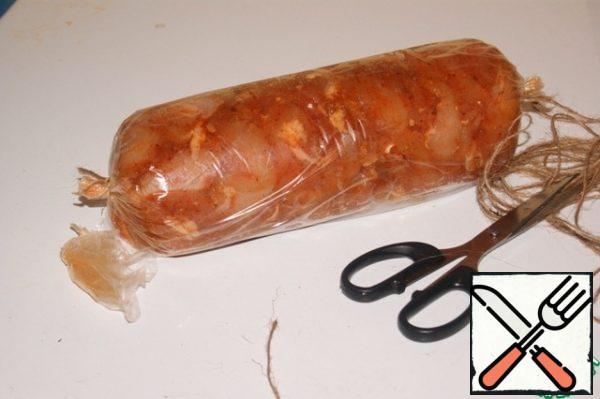 ... take hold of the twisted ends with your hands, and at the same time squeezing the sides, seal the stuffing, a beautiful and dense sausage is formed. With the help of twine, tie the sides and cut off the excess from them.