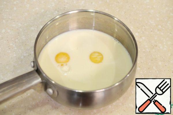 In a saucepan, pour the milk, beat the yolks.