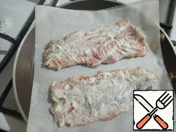 On a dry pan, put parchment paper in two additions. Put the fish on paper and cook it over a fairly moderate medium heat.