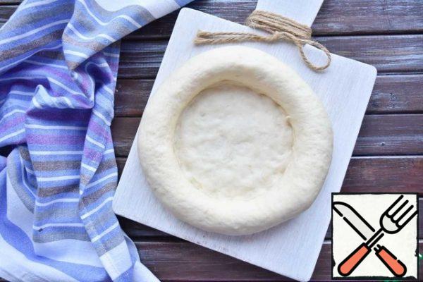 You will get a blank with a thin layer of dough in the middle and thick rounded edges. Leave them for proofing for another 30 minutes.
