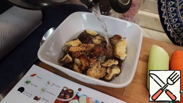 To start, pour the shiitake mushrooms with boiling water. Leave for 15 minutes.