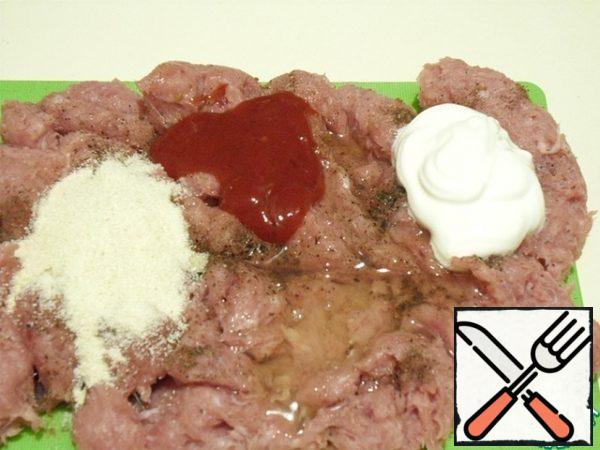 Prepare the minced meat in the usual way, with the addition of onions and at the discretion of garlic.
Add salt, black pepper, egg white, dried herbs to your taste, sour cream, semolina and ketchup or tomato sauce.
Mix everything thoroughly.