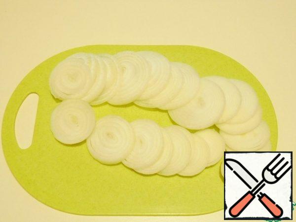 At the right hour, get the workpiece from the freezer until it departs a little from the frost, peel and cut into large rings of onions. Choose the amount of it according to your taste. It turns out very tasty and can serve as a side dish to the medallions.