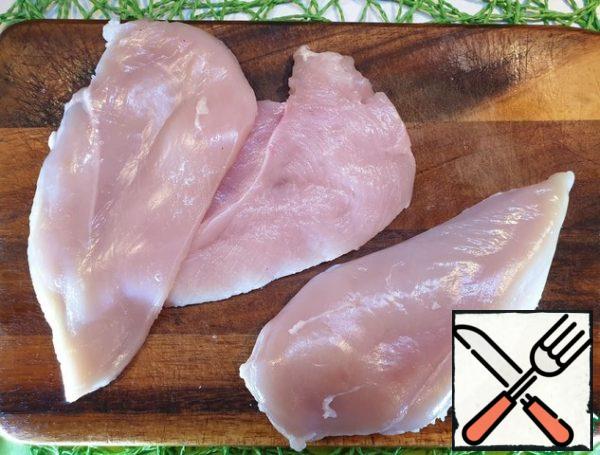 Prepare the chicken fillet.
Cut the fillet into 2 parts lengthwise and beat off a little with the palm of your hand.