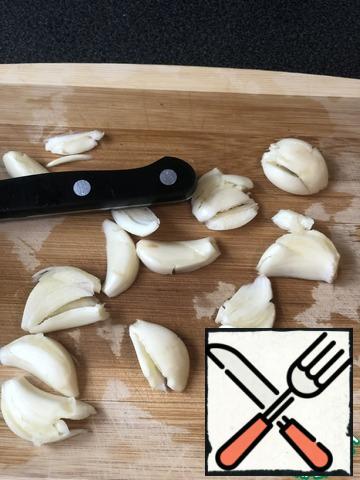 Crush the garlic cloves with the handle of a knife.