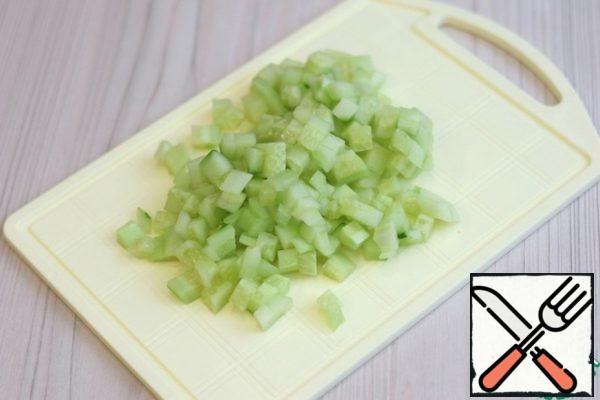Remove the skin from the cucumber (1 PC.). Cut the cucumber into small cubes.
