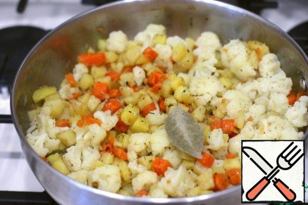 Add cauliflower to potatoes and carrots. Add salt and pepper with ground black pepper to taste, add water, about 1/2 cup. Put the vegetable mixture in a frying pan and simmer until the potatoes and carrots are soft. Cabbage, if desired, can be stewed until Al dente. I want to pay attention, I did not add onions to the vegetable mixture. I cook this side dish without adding onions. If desired, you can add onions. Add the bay leaf three to five minutes before cooking.
