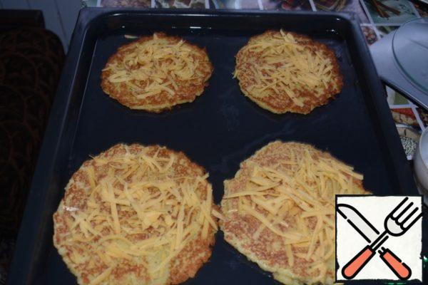 Preheat the oven to 180 gr. Spread the pancakes on a baking sheet, greased with vegetable oil. Pour the meat juice from the fried meat over each pancake. Sprinkle them with 1/2 of the cheese.
