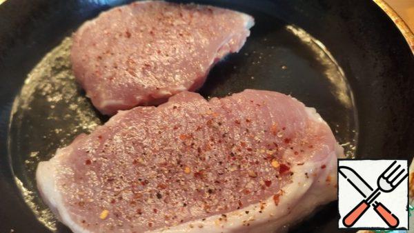 Pepper the pork slices, add salt and fry in vegetable oil.