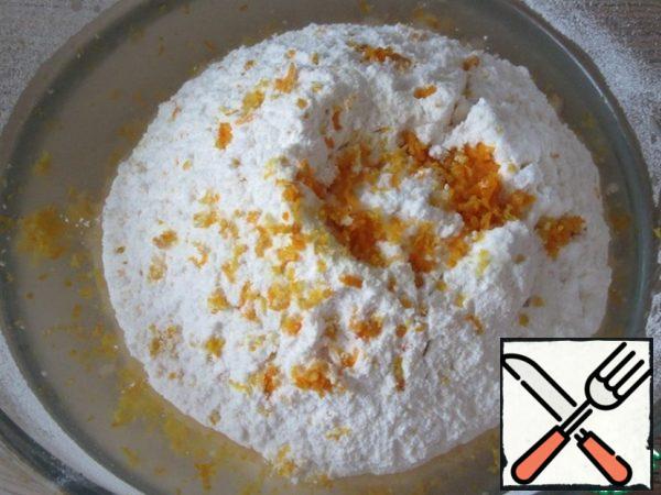 Prepare the dough. In water, dissolve the sugar and salt, add vegetable oil. Add about half of the flour with baking powder, vanilla and lemon and orange zest, and mix.