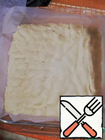 Line a small form with parchment paper and spread the dough evenly with a spatula. I have a form of 21×21 cm.
