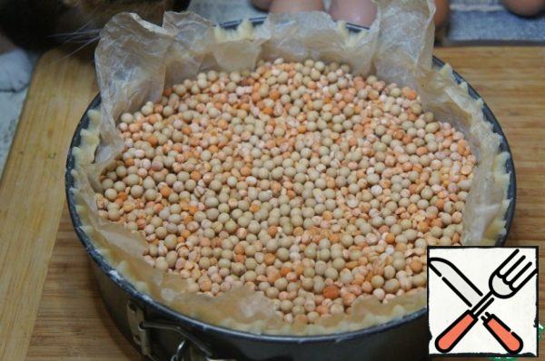 Cover with crumpled parchment paper, pour the beans or peas. Bake for 20 minutes t 170°C, then remove the cake from the oven, carefully pour the peas, remove the parchment.