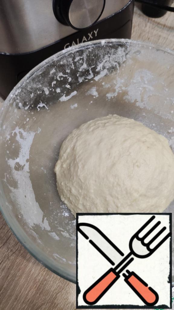 Gradually add the flour and knead a soft, non-sticky dough. Flour can go more or less. Cover the dough and leave to approach in a warm place, until increased by 2 times.
Divide the dough into 2 parts.