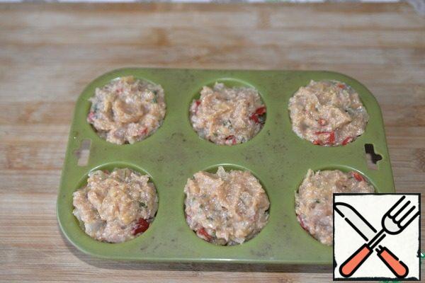 Take the form for the muffin, tightly put the minced meat with a spoon. Do not put it on top (as I did), the juice will pour directly into the oven.
Put the molds in a preheated 200 degree oven and bake for 40 minutes.