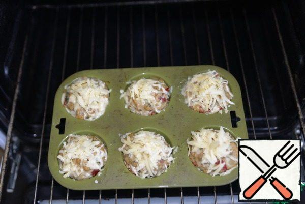 For 10 minutes until ready, sprinkle the muffins with grated cheese. Put a baking sheet on top of the oven or under the grill, if you have one. At maximum temperature, bring the muffins to readiness.