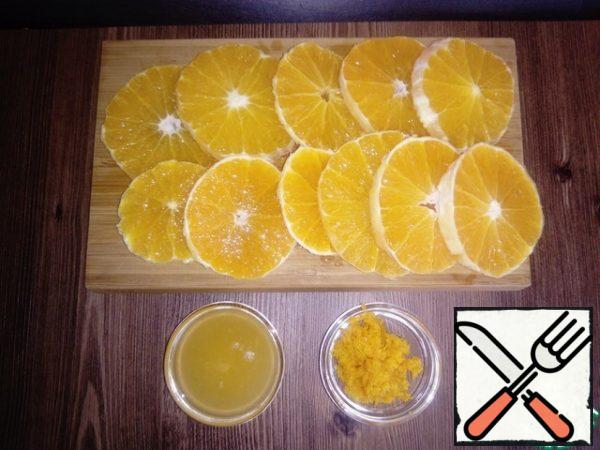 Remove the zest from one orange. Then we clean the oranges (we clean off the completely white part of the orange) and cut them into rings about 5 mm thick. Leave part of the orange and squeeze out 3 tbsp of orange juice.