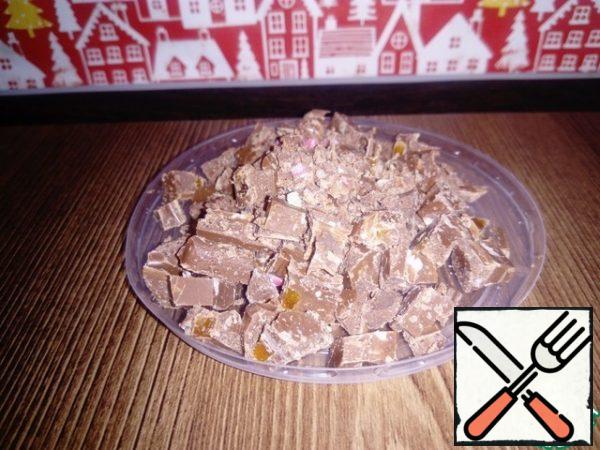 Chocolate is crushed with a knife into small pieces.