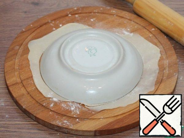 Each piece of dough, roll out into a thin flat cake on a Board dusted with flour. Cut out a circle.