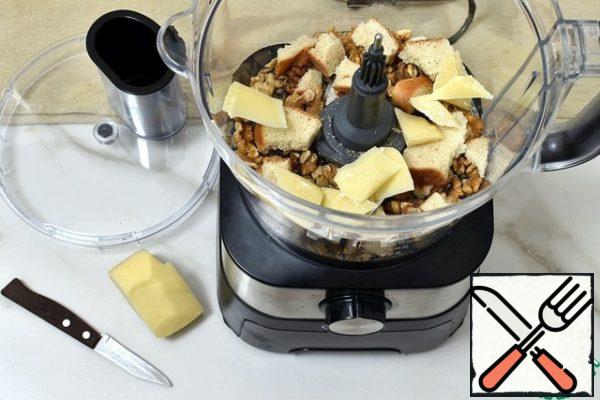 In the bowl of a food processor place the nuts, add broken pieces of dried slices of the loaf and slices of Parmesan.