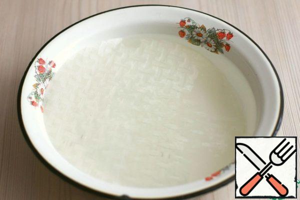 In a bowl of water, soak each successive sheet of rice paper.